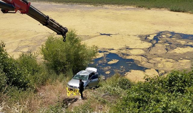Sürücü kurtuldu, otomobil göletten vinçle çıkarıldı